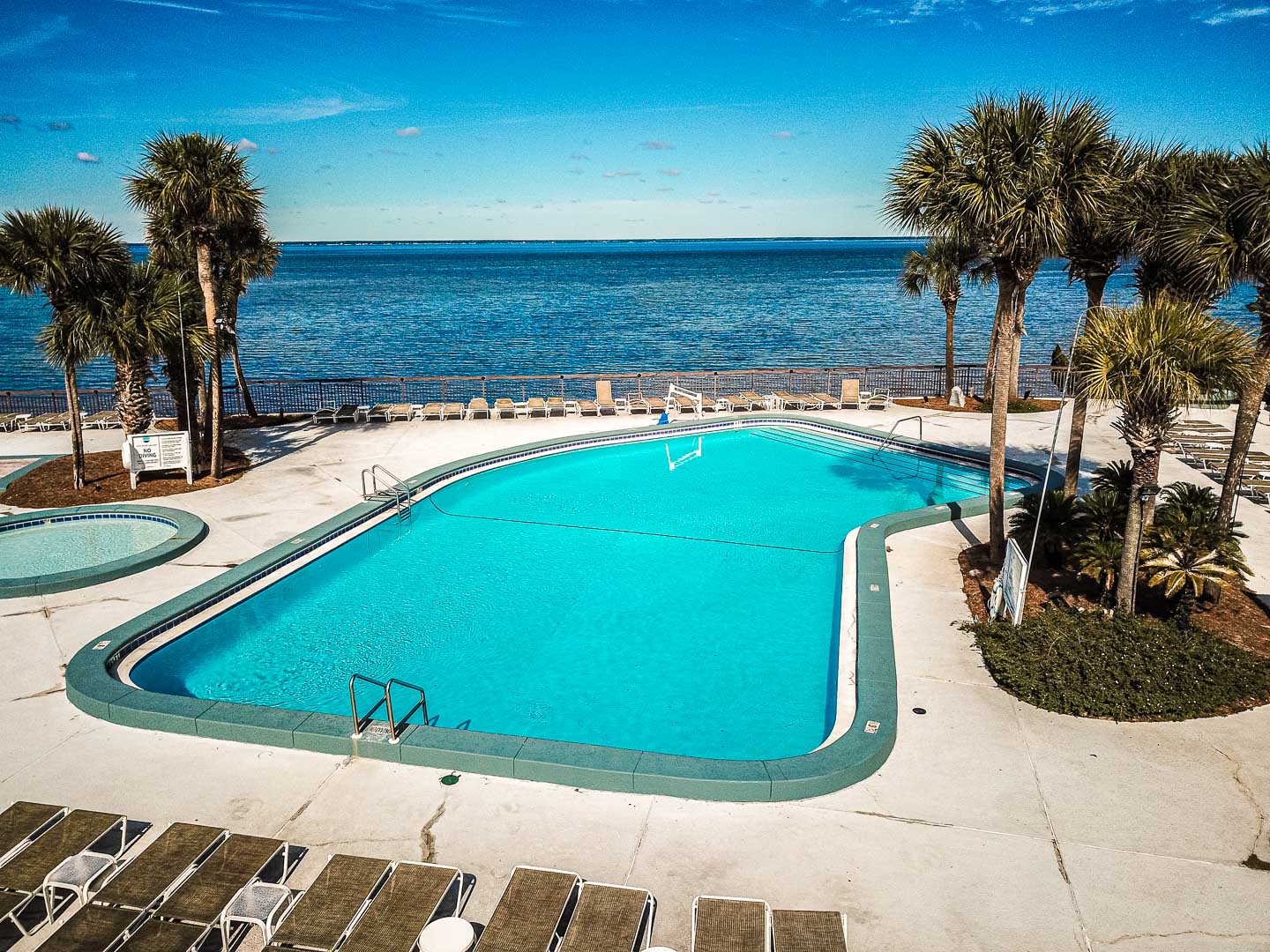 A spacious outdoor swimming pool with a beach view at VRI's Bay Club of Sandestin in Florida.